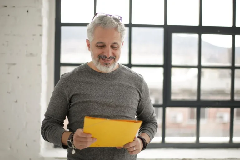 A middle-aged man holding a folder
