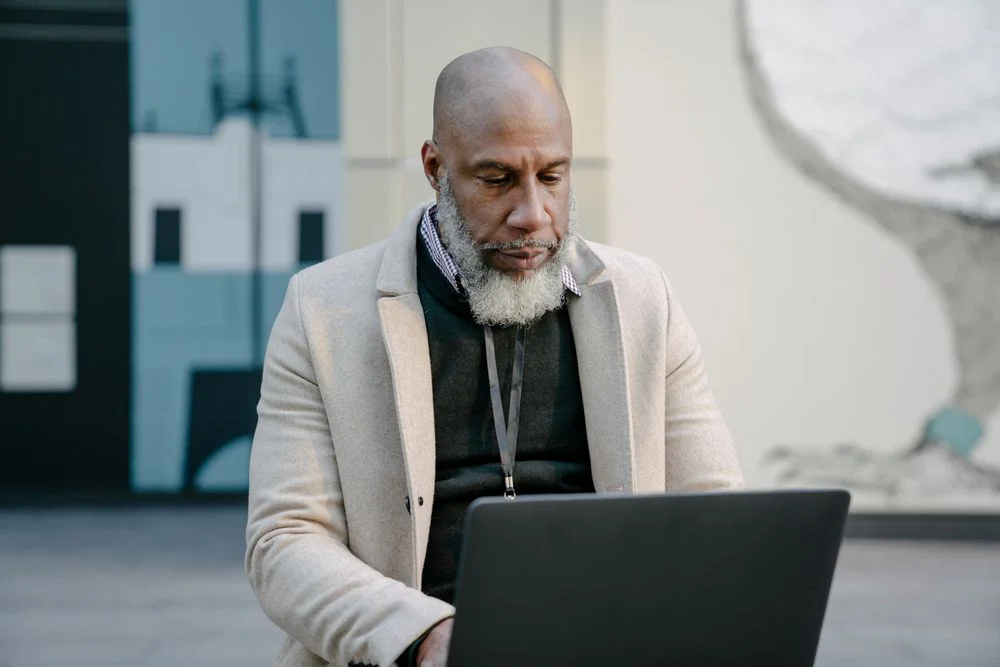 A middle-aged man viewing a laptop